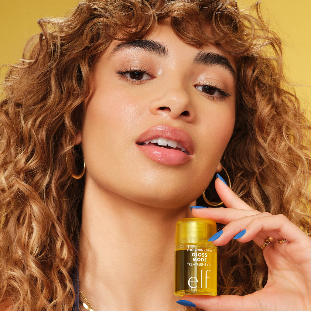 Woman with Curly Hair Holding Gloss Mode Hair Treatment Oil